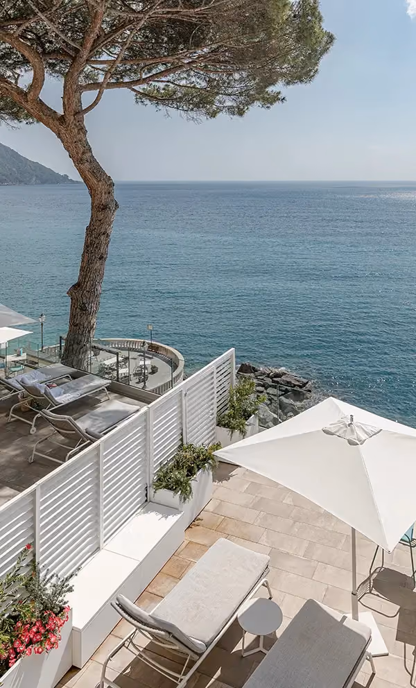 Outdoor setting with bespoke white Modularte screening panels, integrated planters and garden furniture at a sea-view location.