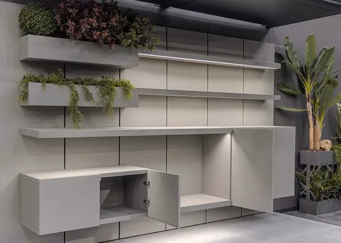 Grey outdoor wall system with some doors open, backlit shelves and integrated planters.