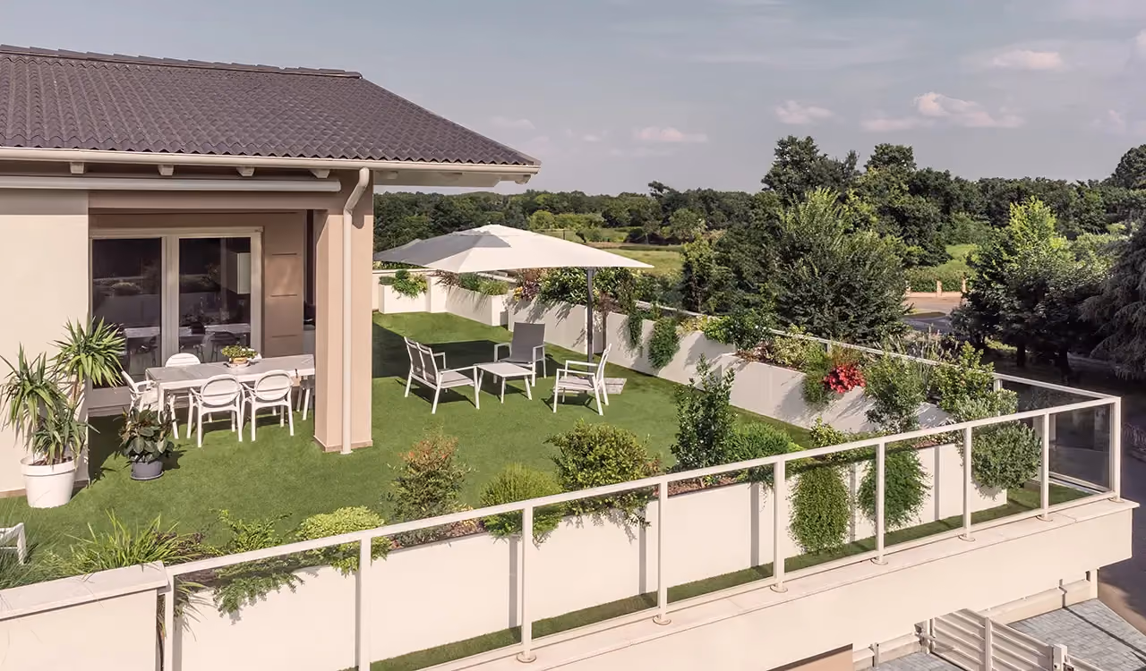 Garden with modular planters along the edge of a terrace, in front of a villa